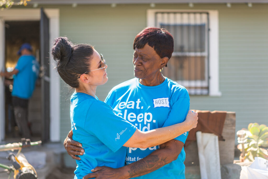 A volunteer embracing a homeowner